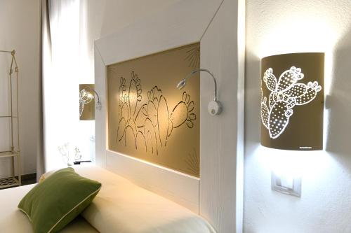 阿尔盖罗ALGHERO NOON的卧室配有一张带墙上灯的床。