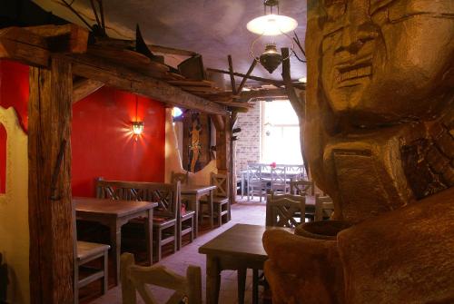 帕尔杜比采庄园牧场旅馆的餐厅设有木桌、椅子和红色的墙壁
