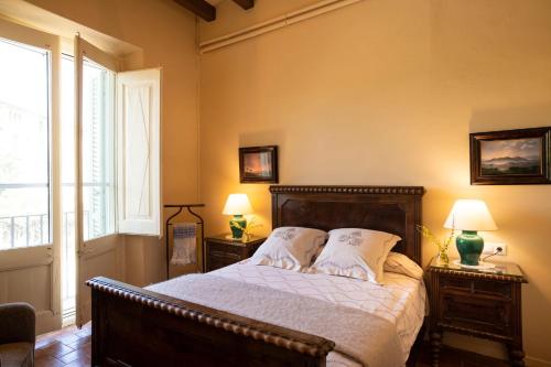 San Pedro de RiudevitllesMasia Can Comas的一间卧室配有一张带2个床头柜和2盏灯的床。