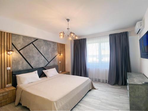 马马亚Ada Luxury Apartments 57的一间卧室设有一张床和一个大窗户