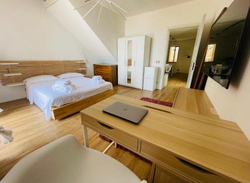 波利卡Sdraiati Apartments - Bed & Breakfast - Pollica的一间卧室配有一张床和一张带笔记本电脑的书桌