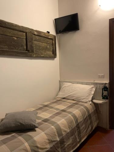 莱德罗Enjoy Ledro B&B的卧室配有一张床,墙上配有电视。