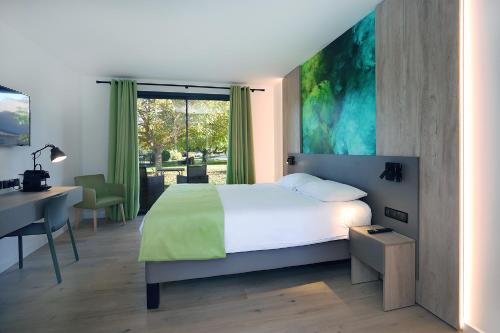 鲁塞Logis Hôtel & Spa Déjeunez Sous L'Arbre的一间卧室配有一张床、一张书桌和一个窗户。