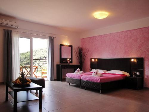 帕尔加Dafni studios no2的一间卧室配有一张床和粉红色的墙壁