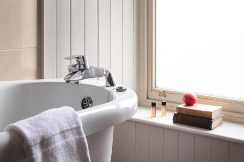 基洛格林比安科尼酒店的白色的浴室设有水槽和窗户。