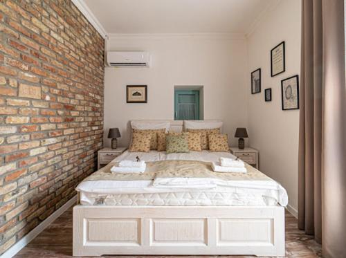 包道乔尼托毛伊Villa Bella的一间卧室设有一张带砖墙的大床