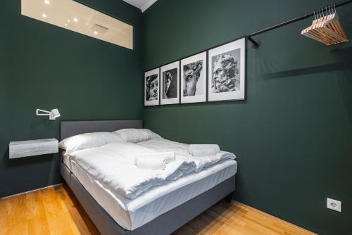 维也纳Trendy apt with - smart TV, coffee machine in Meidling的绿色客房,配有一张四幅画的床铺