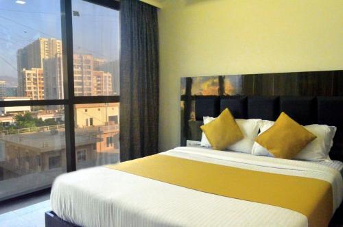 孟买THE BEST HOTEL MUMBAI的一间卧室设有一张大床和一个大窗户
