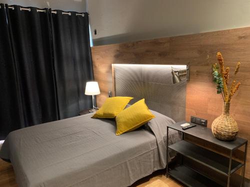 阿尔布费拉Lost & Found - Guesthouse & Suites的一间卧室配有一张带黄色枕头和桌子的床