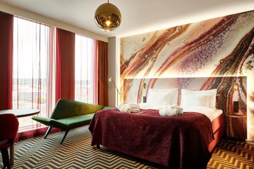 哈尔姆斯塔德ProfilHotels Halmstad Plaza的酒店客房,配有一张床和一把绿色椅子