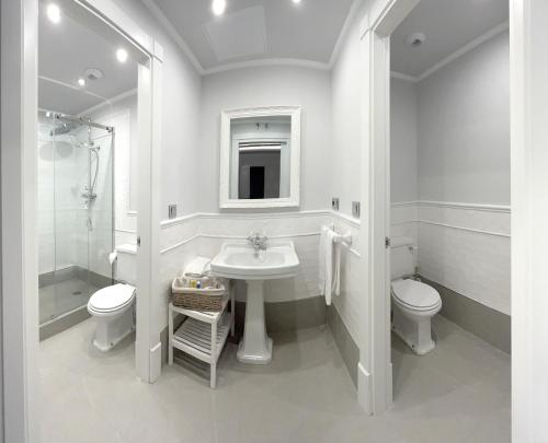 萨拉曼卡Apartamentos El Mirador del Poeta的白色的浴室设有水槽和卫生间。