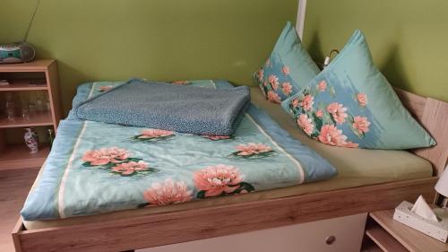 奥斯特巴特宁哈根Wohnung 2的一张带鲜花的蓝色棉被的床