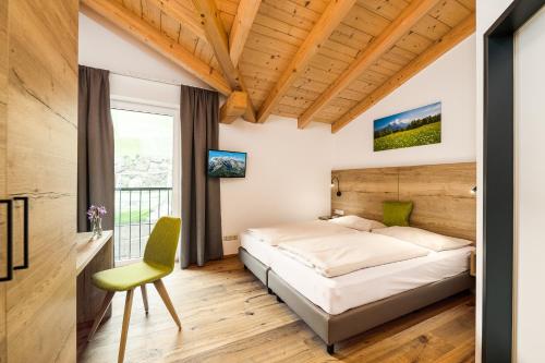 玛丽亚阿尔姆Apartmenthotel Sonnenhof的一间卧室配有一张床和一把绿色椅子