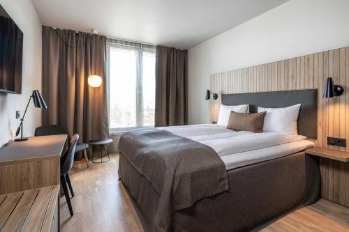 斯彻达尔瓦尔内斯品质机场酒店的酒店客房设有一张大床和一张书桌。