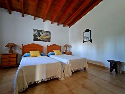 圣费兰-德瑟斯罗Ca n'Antonia的配有白色墙壁和木地板的客房内的两张床