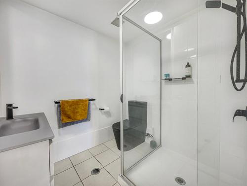 马库拉Seaside Stays Marcoola Beach Studio Room的带淋浴、卫生间和盥洗盆的浴室