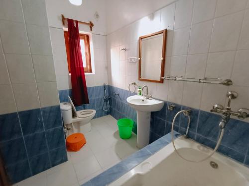 菩提伽耶The Gupta Guest House的带浴缸、盥洗盆和卫生间的浴室
