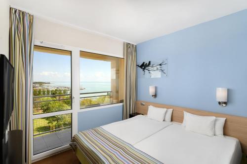 巴拉顿菲赖德Danubius Hotel Marina的一间卧室设有一张床和一个大窗户