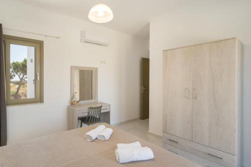 德里奥斯Hercules house pyrgaki paros的一间白色卧室,床上配有2条毛巾