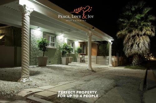 伊丽莎白港Peace Love and Joy Self Catering Units的棕榈树在晚上点燃的房子