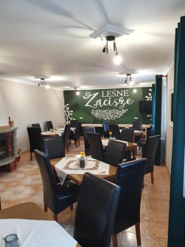 WeremieńLeśne Zacisze的一间带桌椅和绿色墙壁的用餐室