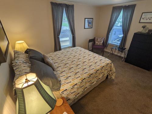 米尔福德The Estate Loft in Downtown Milford的一间卧室设有一张床和两个窗户。