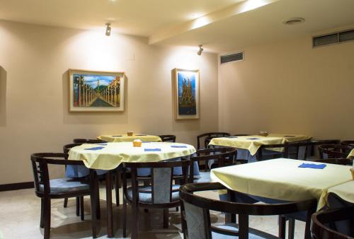 巴塞罗那Atlantis by Atbcn的餐厅的一排桌子,有白色的桌子