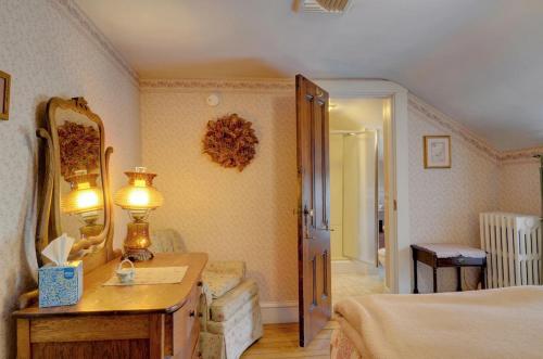 纽波特纽波特梅尔维尔酒店的一间卧室配有一张床、一个梳妆台和镜子