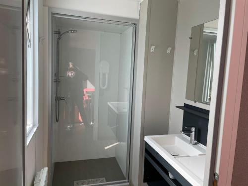 坎佩尔Mobilhome tout confort M9 domaine de Lanniron的把淋浴的照片拍到浴室的人
