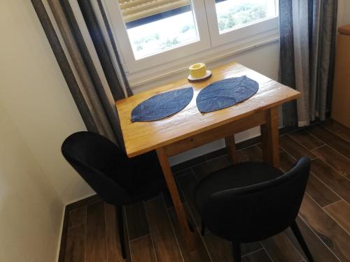 里耶卡Studio apartman Noa的一张带两把椅子的木桌和窗户