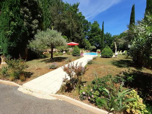 萨尔拉拉卡内达Studio Domaine des Oliviers的一个带人行道和游泳池的花园