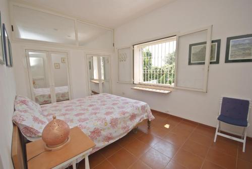 加利亚诺德尔卡波TRULLO MEDITERRANEO - SANTA MARIA DI LEUCA的一间卧室配有一张床、一张桌子和一个窗户。