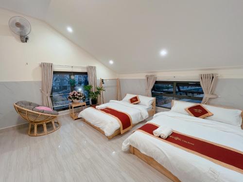 大叻Ánh Vân Villa hotel的一间卧室设有两张床和窗户。