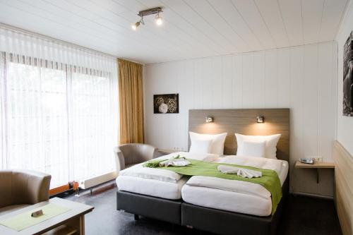 耶弗尔弗里森酒店的一间卧室配有一张带绿毯的大床