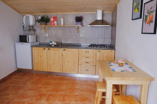 戈伊什Casinha da Eira的厨房配有木桌、桌子、桌子和柜台。
