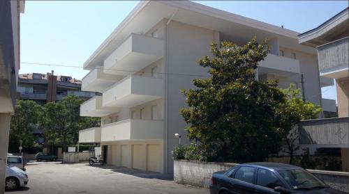 蒙特西尔瓦诺Elegante appartamento a due passi dal mare的前面有停车位的建筑