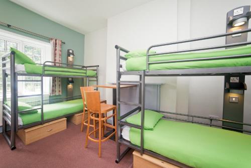 阿什伯恩伊拉姆厅青年旅馆的带两张双层床和椅子的房间
