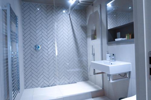 约克City Centre Luxury studio apartment suite with garden view的白色的浴室设有水槽和淋浴。