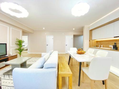乌兰巴托105m2 Central 3 BR new apartment w airport pickup的客厅配有白色的沙发和桌子