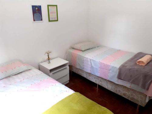 里约热内卢Lindo quarto na Praia de Botafogo的一间客房配有两张床,一个床头柜配有两张床