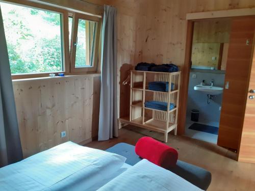 林德伯格Chalet Muehlwiese的一间卧室配有床、水槽和窗户