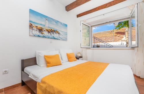 索布拉Apartman Daniela的一间卧室配有带橙色枕头的床和窗户。