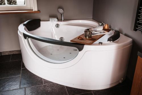 托伦-NIEUW- Luxe & sfeervol Vakantiehuis Tholen的浴室内设有大型白色浴缸。