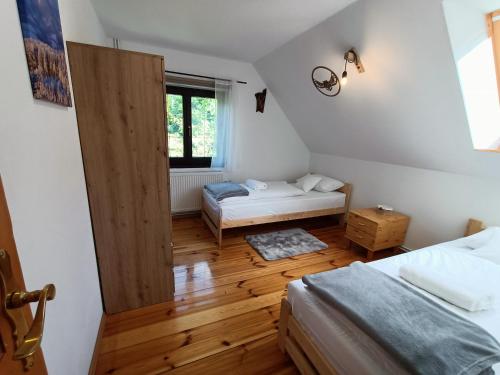 RzeczkaDom nad Potokiem Sowa的小房间设有两张床和窗户