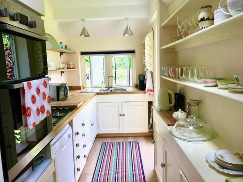 BrimscombeKey Cottage, sleeps 8的厨房配有白色橱柜和水槽