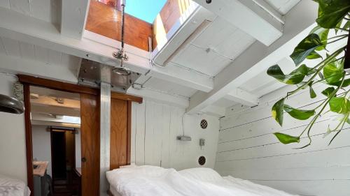 海斯勒Unique Boat Accomodation - Bornholm的卧室拥有白色的墙壁和白色床单。
