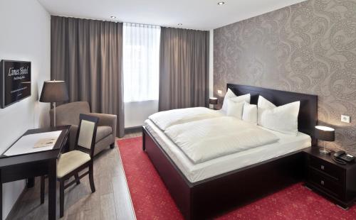 Wehrheim莱姆斯酒店的酒店客房配有一张床、一张书桌和一张书桌。