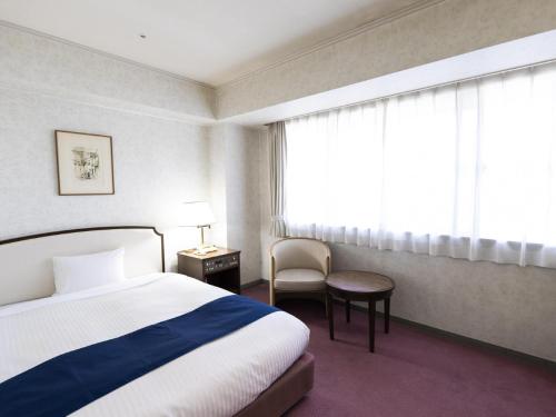 神户神户阿里斯顿酒店的酒店的客房 - 带一张床、椅子和窗户