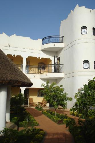 巴马科马里威尼斯酒店的一座大型白色建筑,设有阳台和树木
