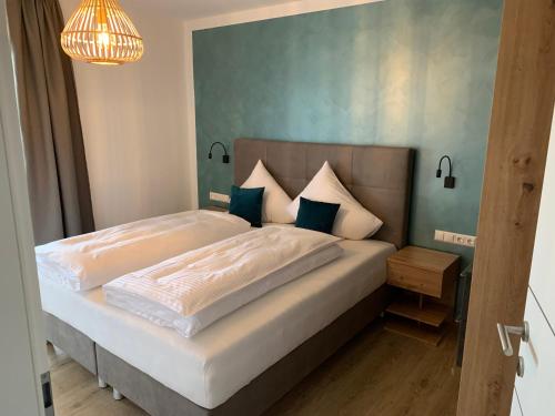 法克湖畔杜罗博拉赫Lieblingsplatzl - Das Apartmenthaus的一间卧室配有一张带蓝色墙壁的大床